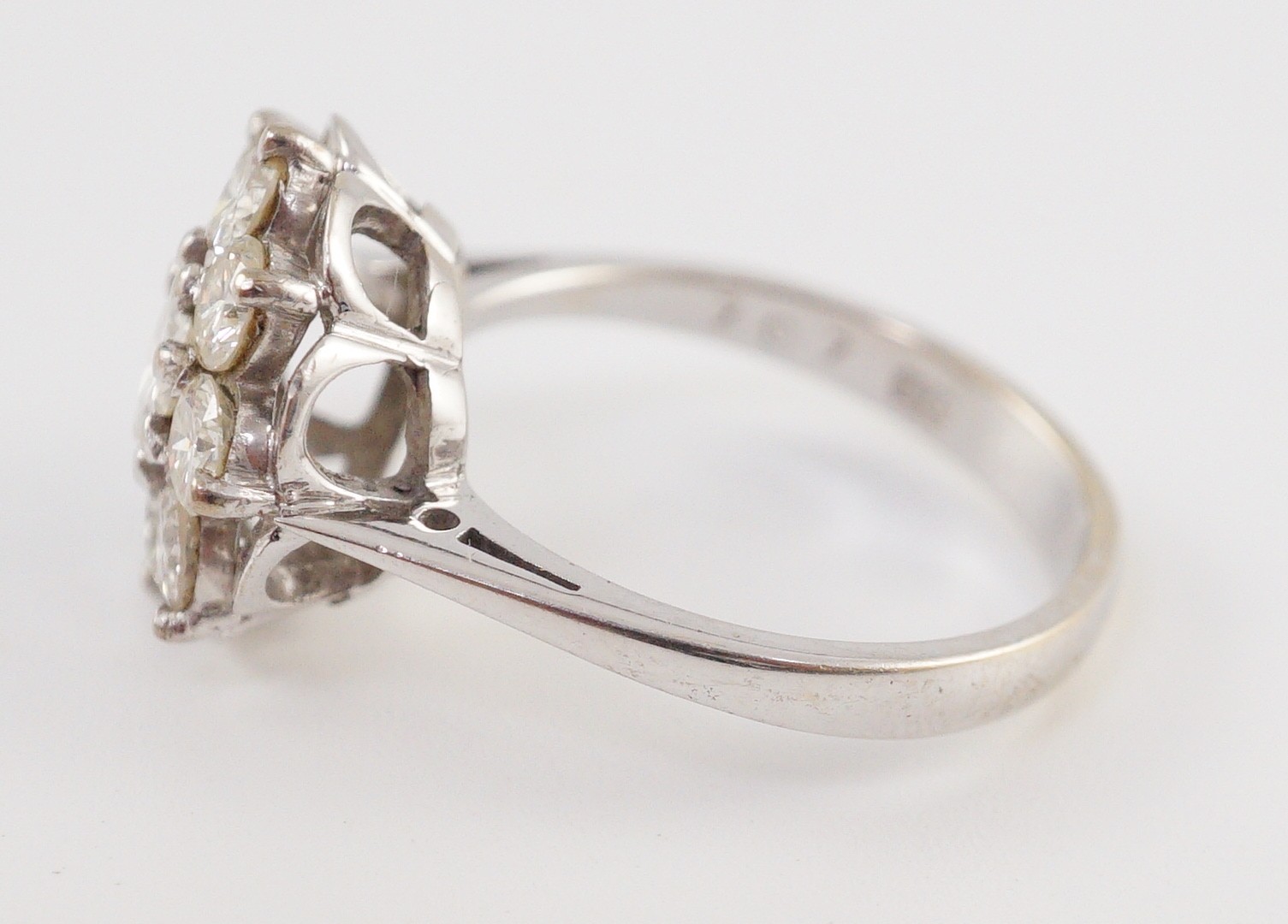 A modern 18ct white gold and nine stone diamond illusion set circular cluster ring